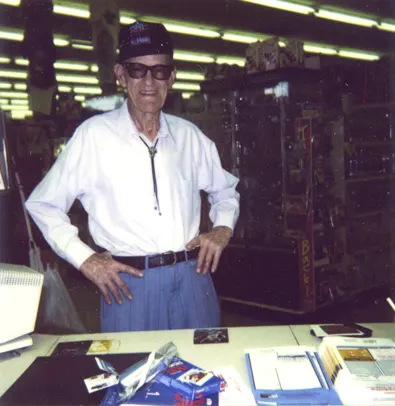Arch Brooks standing at desk in shop.